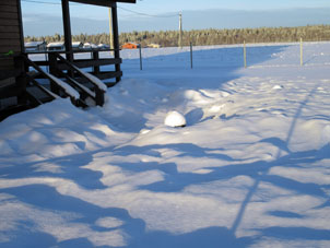 Barbacoa con tapa olvidada en el patio de mi vecino está cubierta con nieve.
